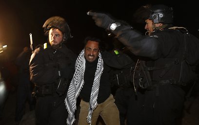 אחד הפלסטינים מורחק מהמקום (צילום: רויטרס)