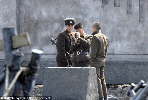 Chilling out: North Korean soldiers can afford a laugh despite the escalating missile crisis