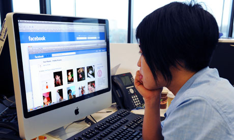 A woman views her profile on Facebook